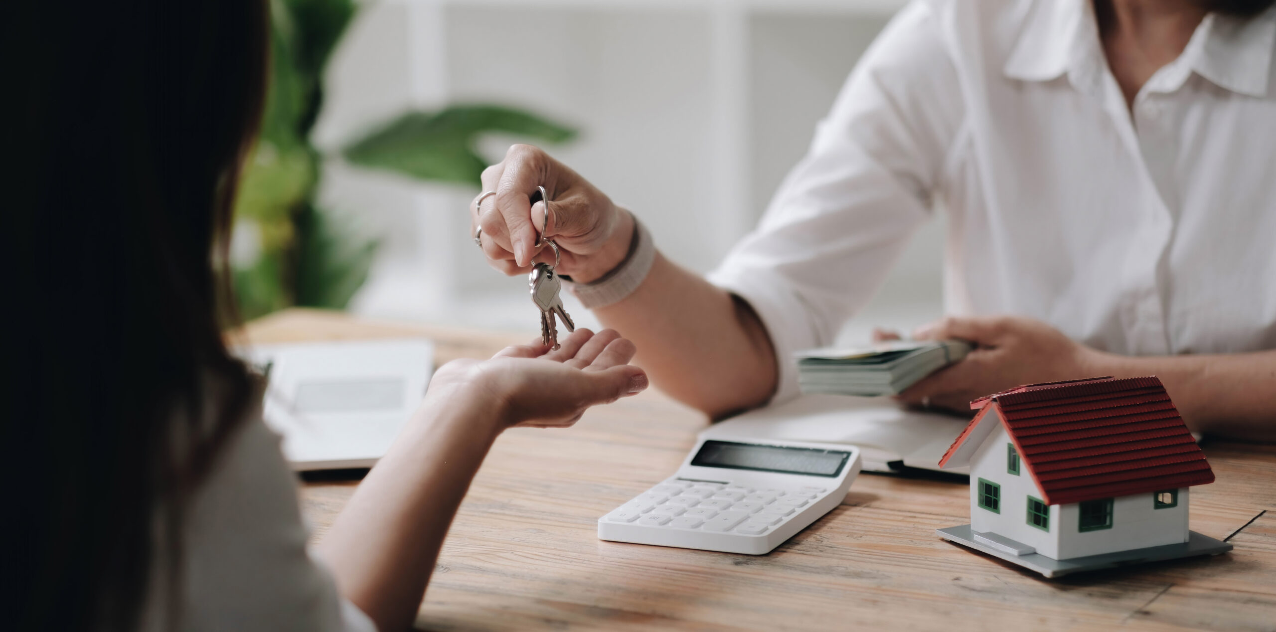 A new landlord receives a house keys chain from a real estate br